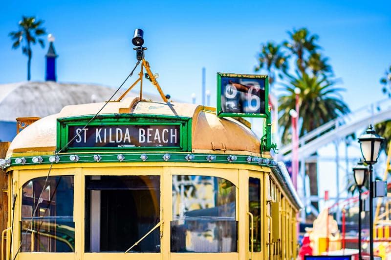a vintage tram in melbourne on a sunny day in colorful surroundings