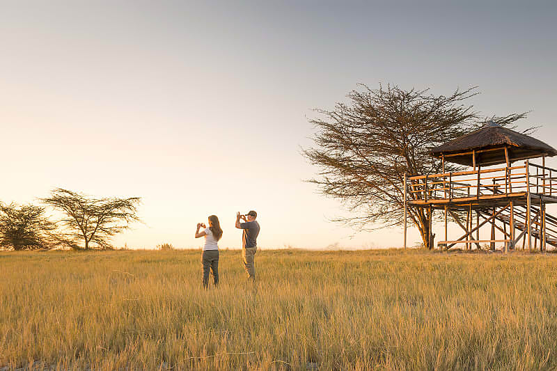 Couple on African Safari Honeymoon in Botswana Honeymoon couple taking pictures on safari in Botswana