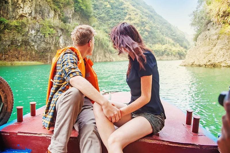 Couple traveling on back of boat in Thailand