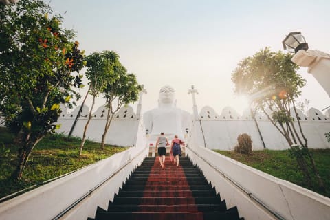 Couple walking up the steps at Bahirawakanda Temple in Kandy, Sri Lanka