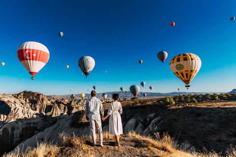 Couple watching the hot air balloons launch in Cappadocia, Turkey