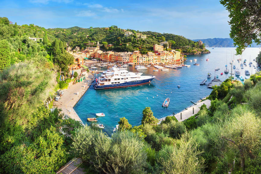 Yachts and small boats in the harbor of colorful coastal Italian town of Portofino