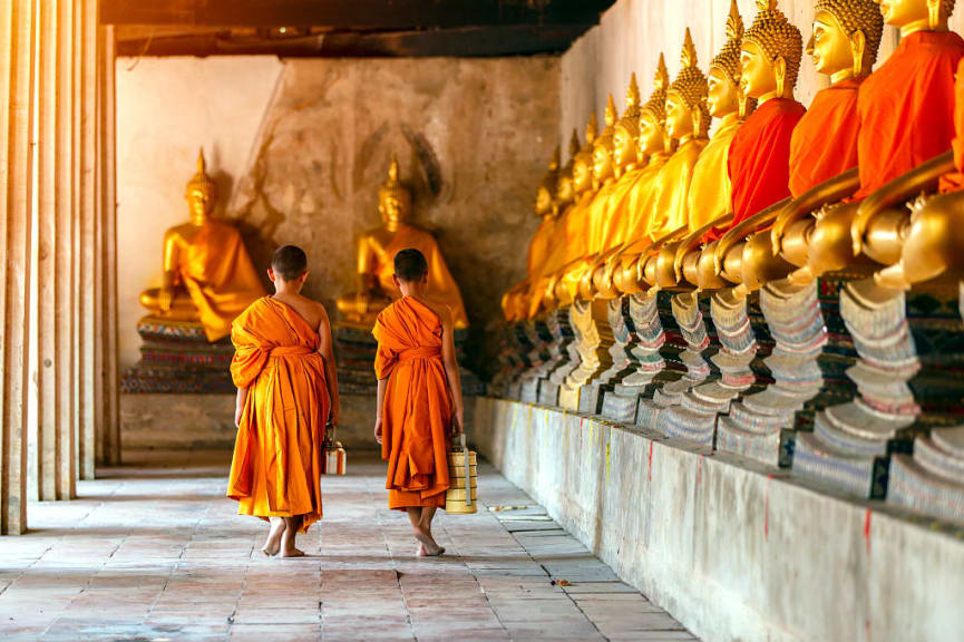 Novice monks walking through a temple in Thailand