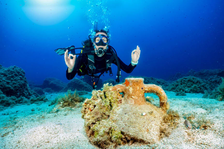 Diver posing with and amphora in the Aegean sea