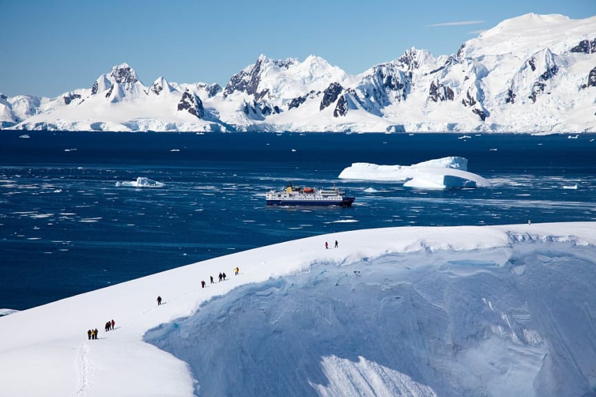 People exploring  snowpacked Antarctica