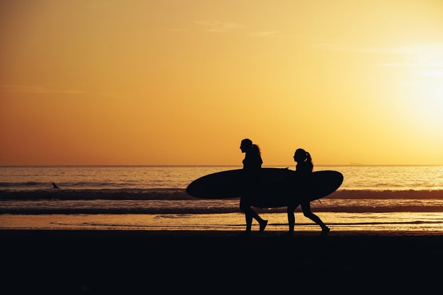 Surfers enjoying beach during sunset in Taghazout