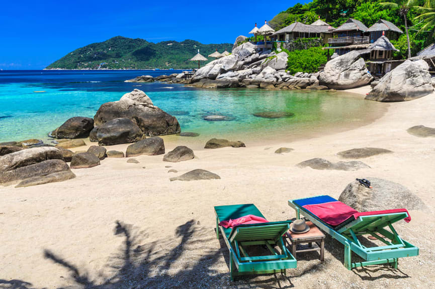 White sandy beach with two lounge chairs in Kho Tao, Thailand