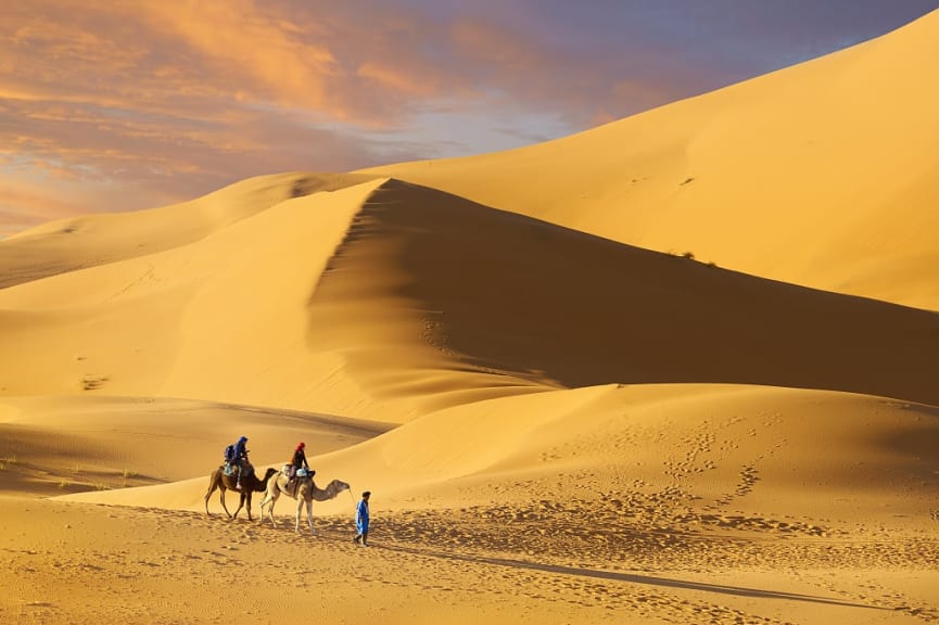 Couple riding camels in Erg Chebbi, Morocco