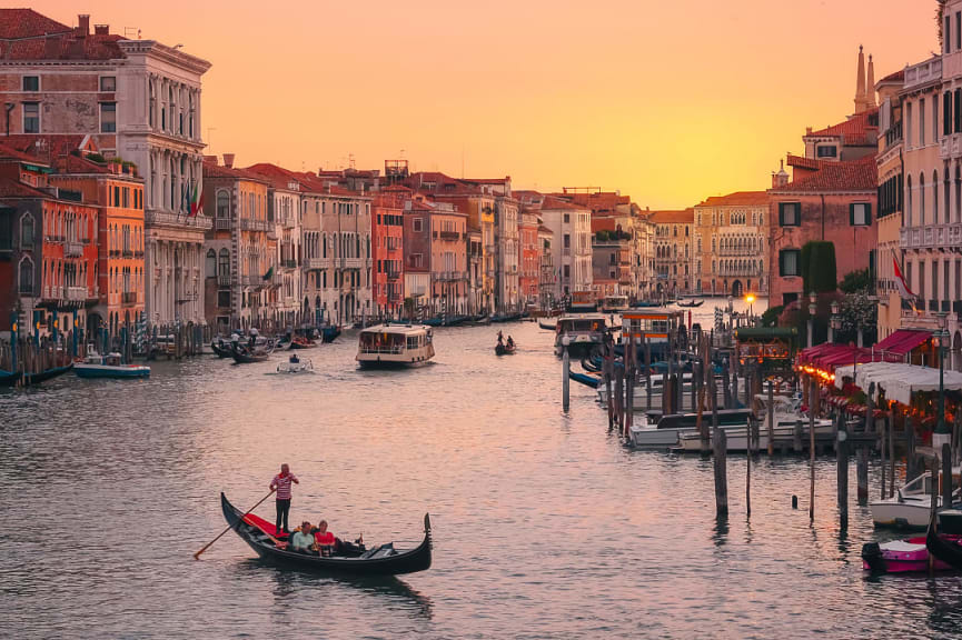 Couple on a romantic sunset gondola ride on the Grand Canal in Venice, Italy