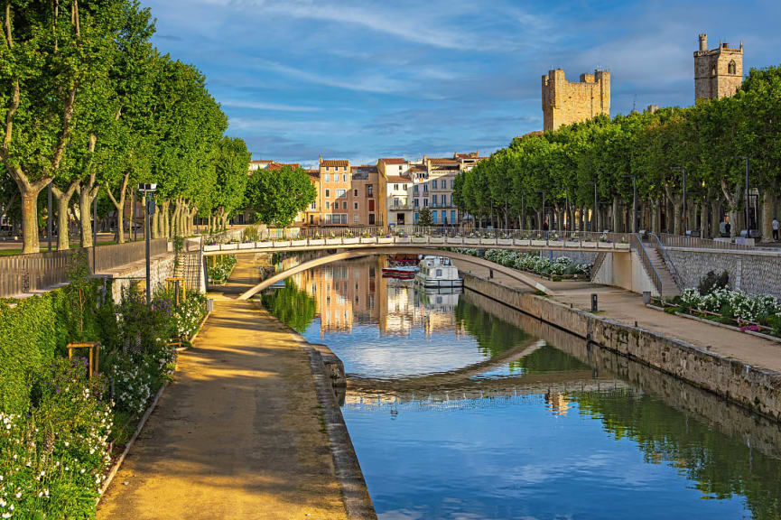 Tree lined walking path along the river in Narbonne, France