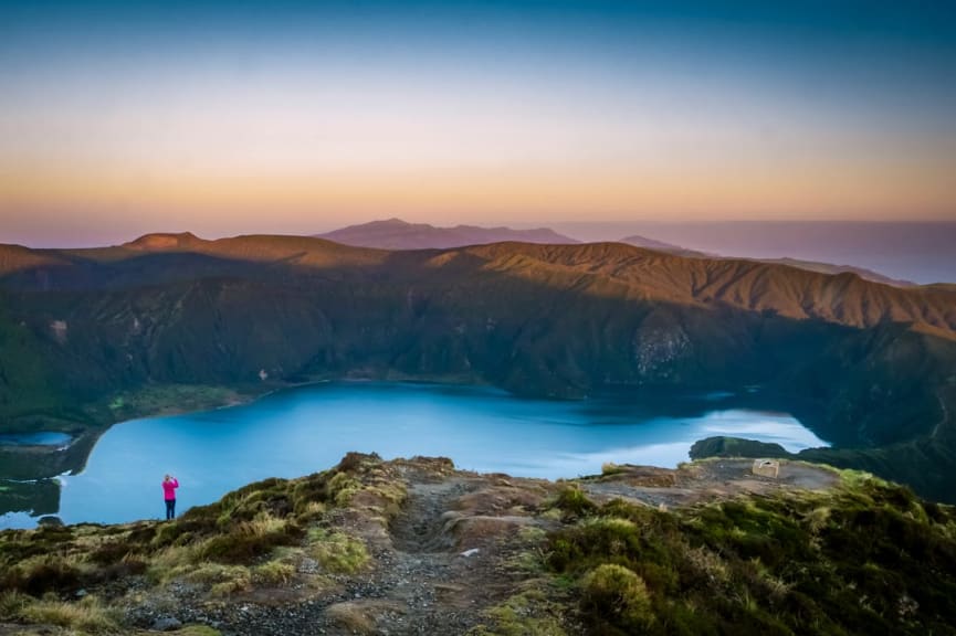 Woman traveller taking photos at Lagoa do Fogo crater lake in the Azores