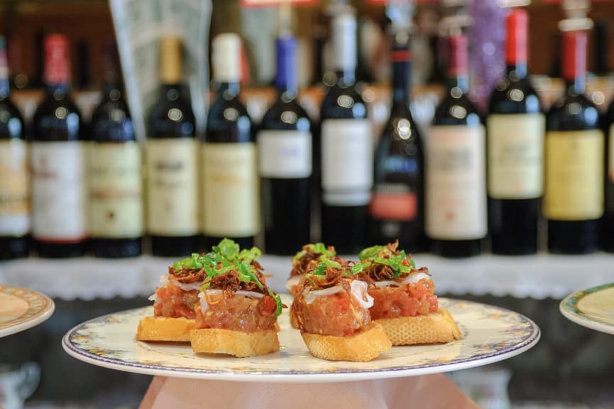 Pintxos with wine bottles in the background in San Sebastian, Spain