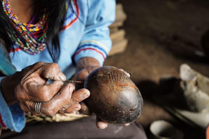 Indigenous Amazonian woman painting mokawas in Ecuador