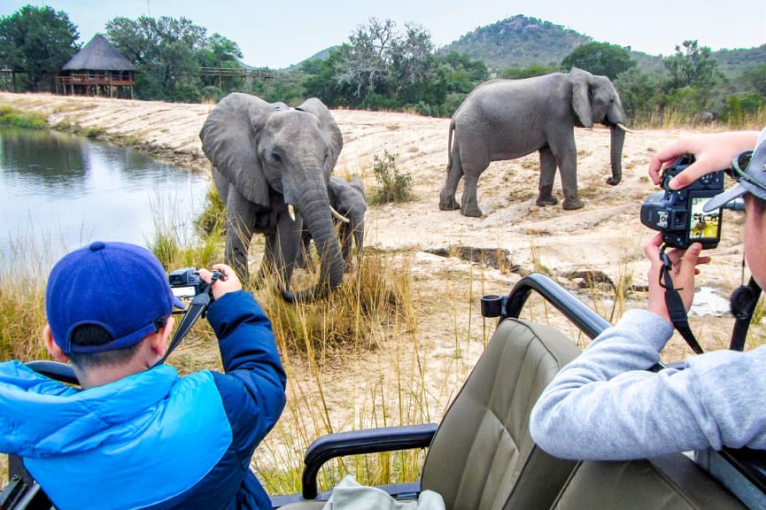 Two kids photographing elephants in Kruger National Park, South Africa