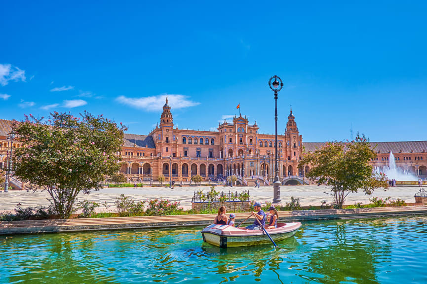 Family boating in the canal at Plaza de Espana in Seville, Spain