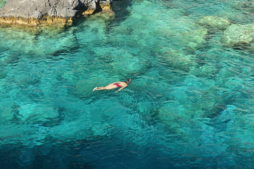 Young woman snorkeling in the turquoise waters at Plakaki Cape, Zakynthos island, Greece