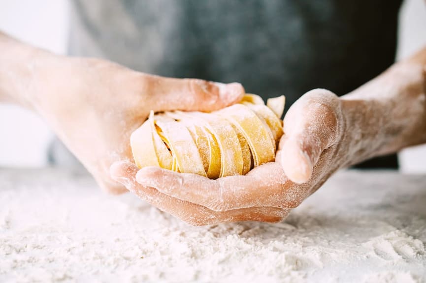 Closeup of hands holding fresh traditional homemade italian pasta