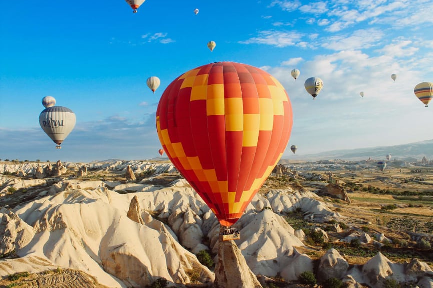 Hot air balloons over rock formations in Cappadocia, Turkey