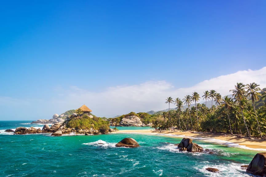 Palm trees and blue Caribbean water on the beach of San Juan del Guia in Tayrona National Park, Colombia