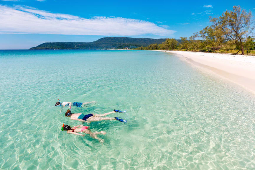 Mother with her two kids snorkeling in shallow water on the beach at Koh Rong, Cambodia