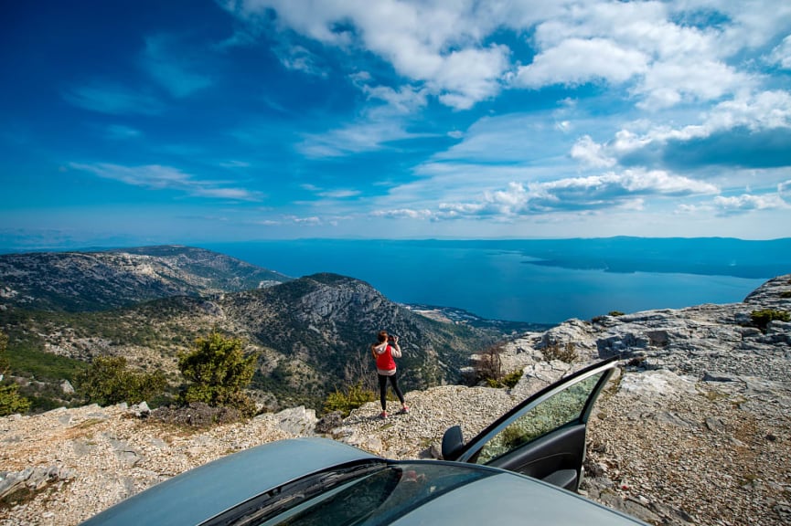 Tourist taking a photo of the view from the roadside in Croatia