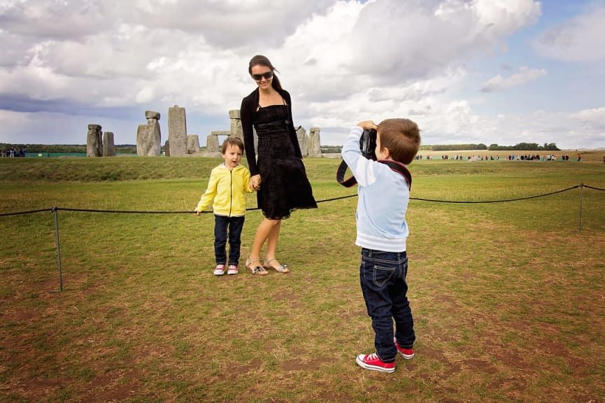 Son taking photo of his sister and mother at Stonehenge in England