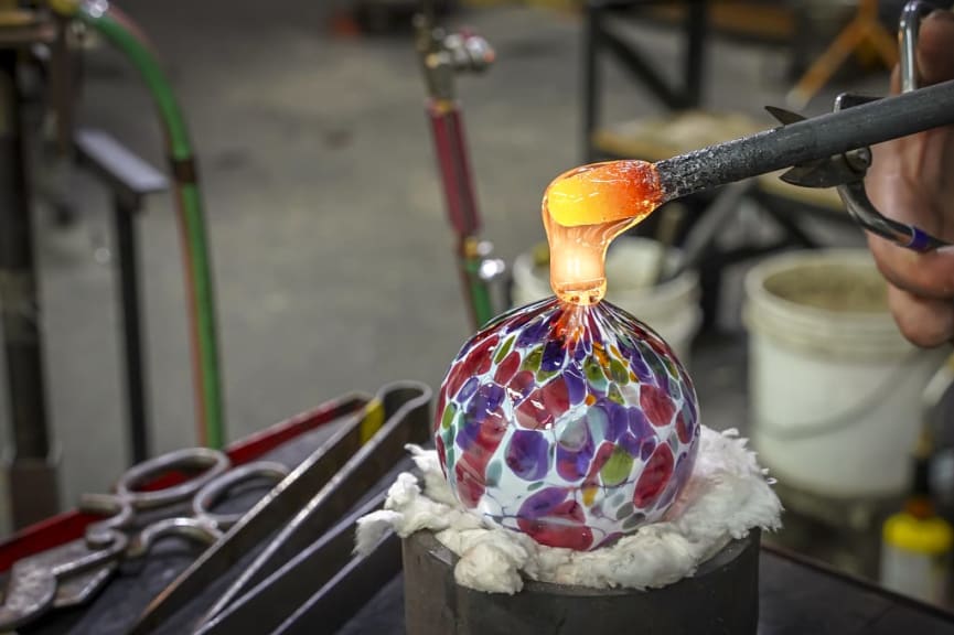Beautiful glass ball being made by a glass blower
