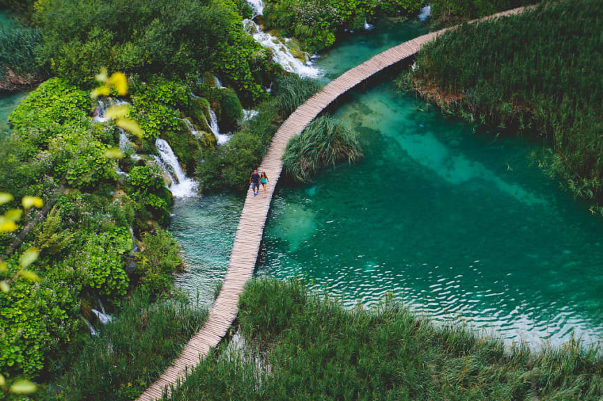 Couple walking along the path in Plitvice Lake National Park, Croatia