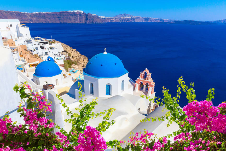 Traditional white houses and churches with blue domes overlooking the caldera and the Aegean Sea in Santorini, Greece