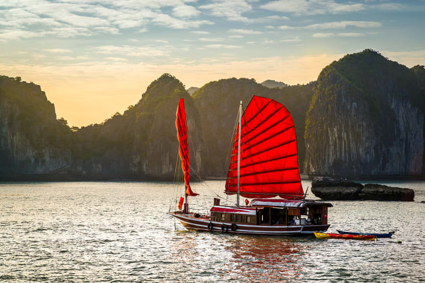 A red junk boat sailing in Ha Long Bay in Vietnam