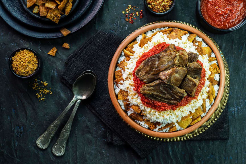 Egyptian cuisine of fettah with rice and crispy bread topped with garlic red sauce and veal