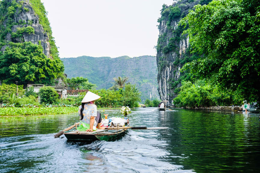 Woman canoeing on Coc Grott, Ninh Binh, Vietnam.