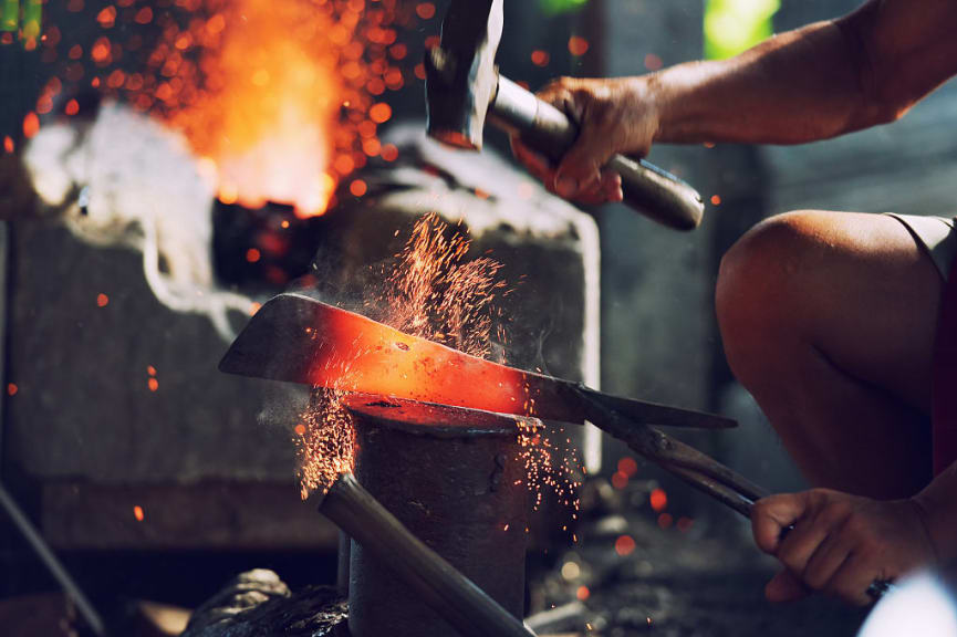 Blacksmith working metal on an anvil