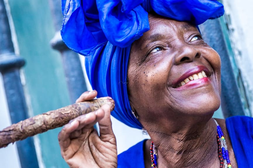 Portrait of a Cuban woman smiling an smoking a cigar in Havana, Cuba