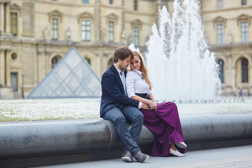 Couple in Paris with the Musée de Louvre in the background, France