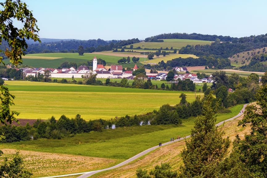 Cyclists and pedestrians on Altmühltal Radweg through farmlands and towns