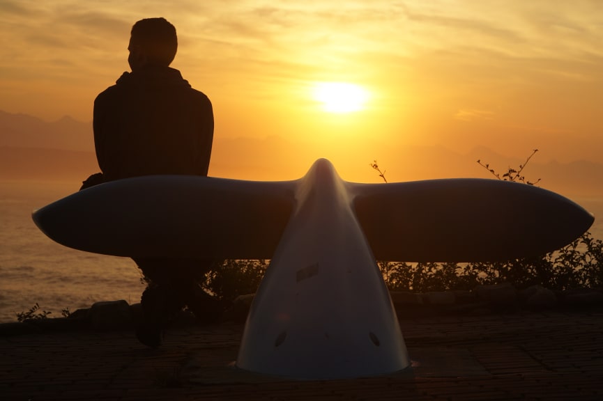 Person sitting on a whale tale shaped bench in Plettenberg Bay, South Africa