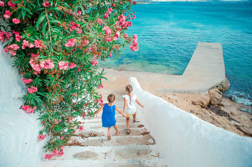 Two little girls on the waterfront, Mykonos, Greece