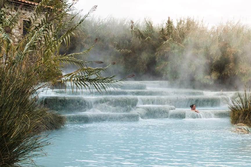 Woman luxuriating in the thermal hot springs at Saturnia during winter in Italy