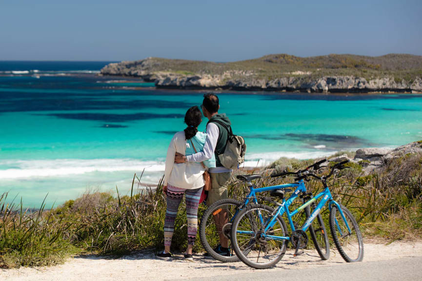 Couple with bikes at Salmon Bay on Rottnest Island, Australia