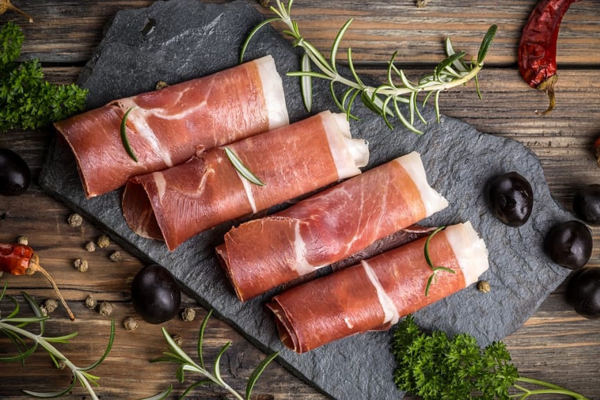 Prosciutto di Parma with rosemary sprig and olives