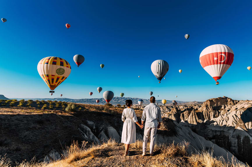 Couple watching the hot air balloons lift off in Cappadocia, Turkey