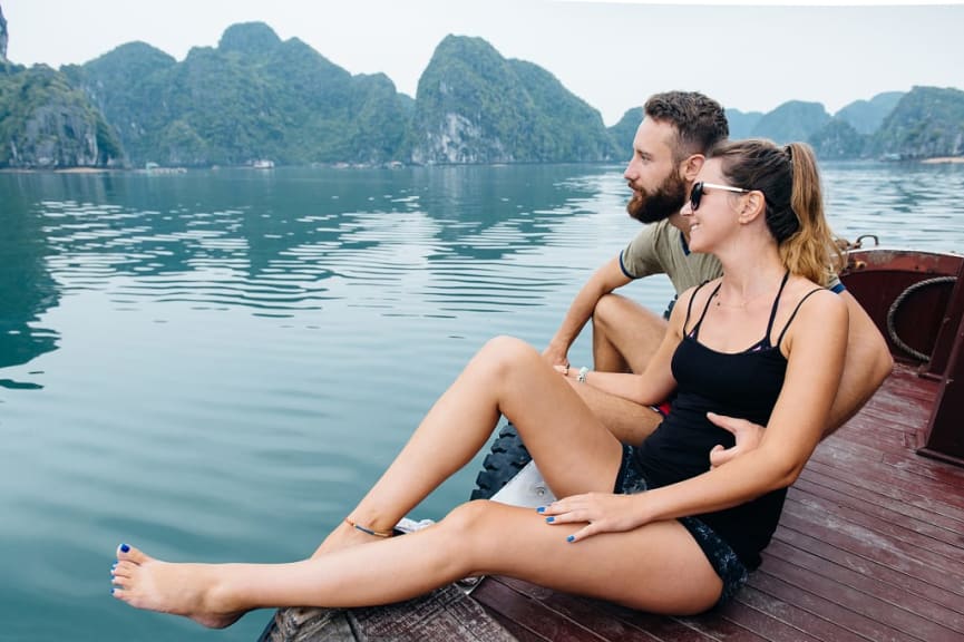 Couple on the deck of cruise ship enjoying the view of Ha Long Bay in Vietnam.