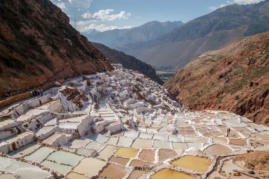 Group of travelers with a guide overlooking the Salt Mines of Maras in Peru