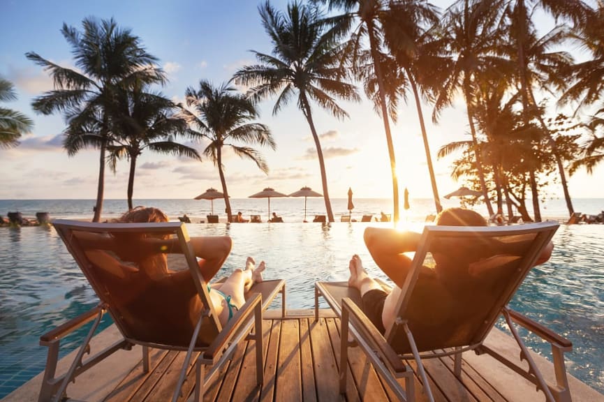 Couple lounging by the pool with a view of the beach in Fiji