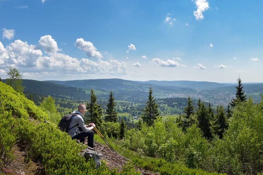 Hiker taking in the scenic landscape of mountains and trees on the Rennsteig Trail in Thuringian Forest