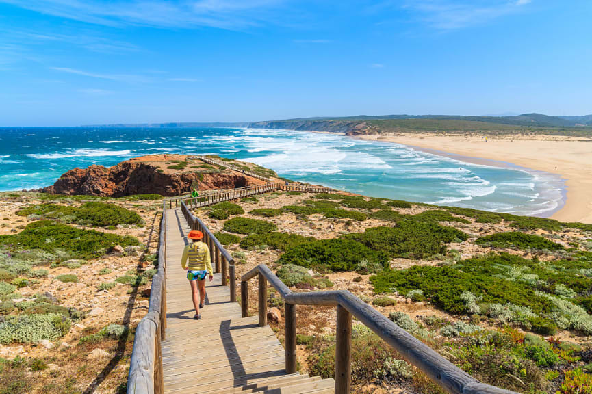 Young woman tourist on the walkway to Praia da Bordeira beach