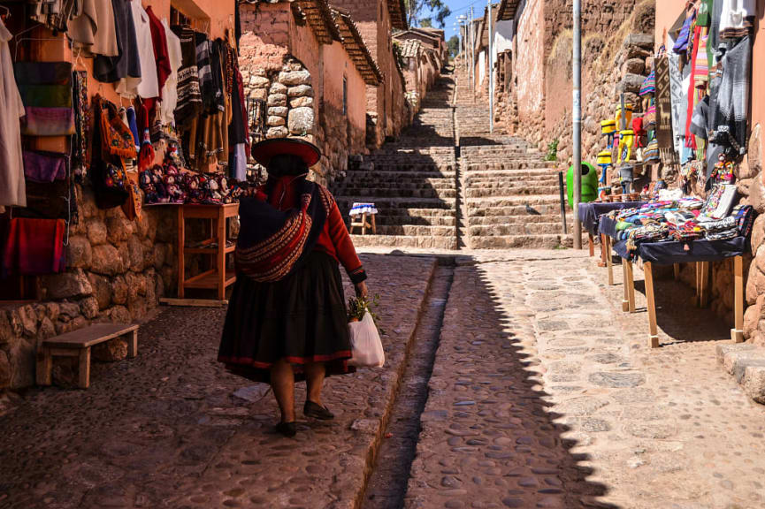 Woman in traditional Peruvian clothings walking in Chinchero village