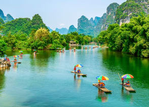 Tourists on bamboo boats floating down the Li River between the karsts in Guilin, China