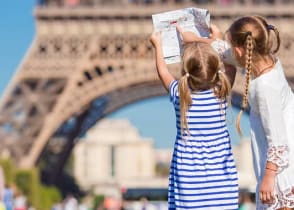 Little girls with a map of Paris on the background of the Eiffel tower, Paris